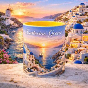 Santorini Greece sunset coffee mug with vibrant coastal village, blue domes, sailboat, and golden ocean view on an accent mug