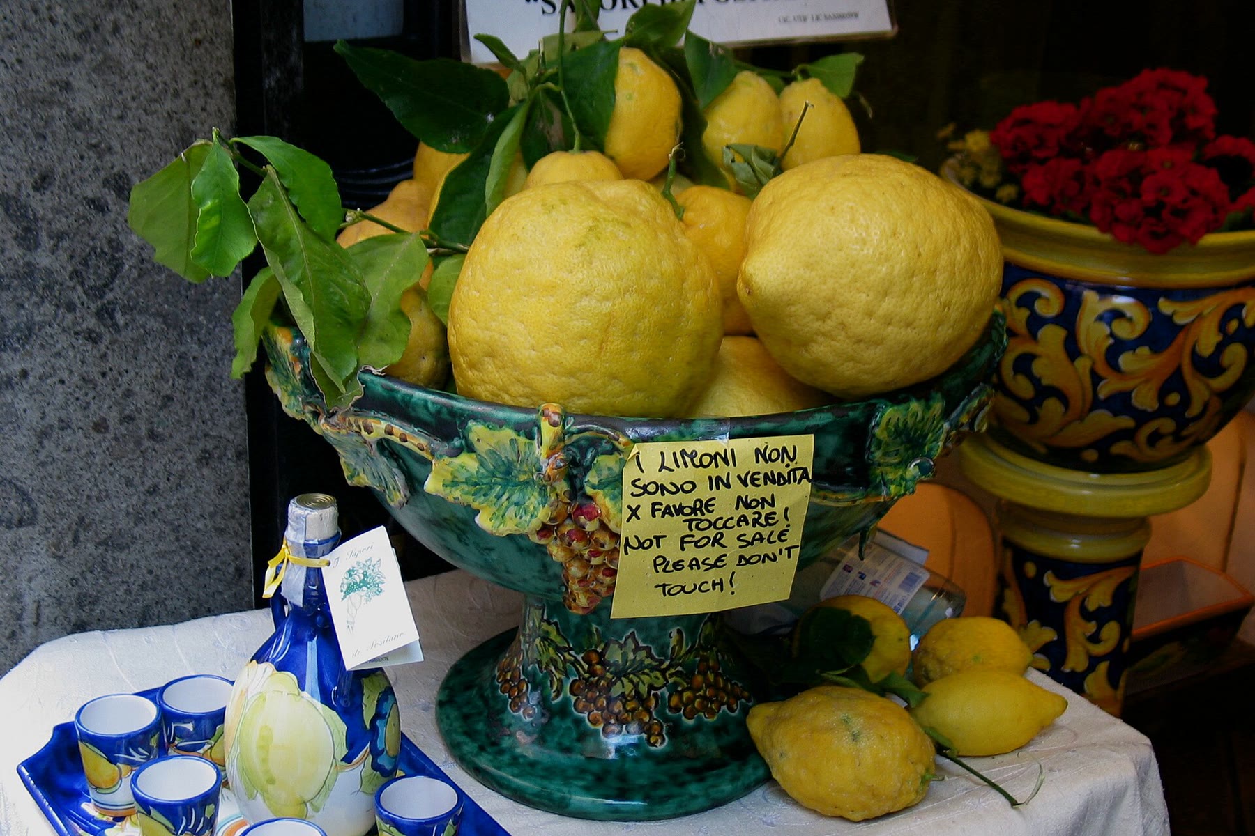 Lemons and limoncello on a rustic table, Amalfi Coast cuisine that shows what lemons symbolize in Italy beyond postcards