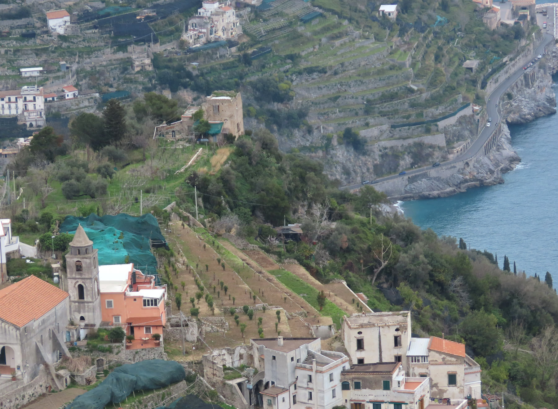 Terraced Amalfi Coast crops and steep road on cliffs, place-as-pressure for romance books set in Italy