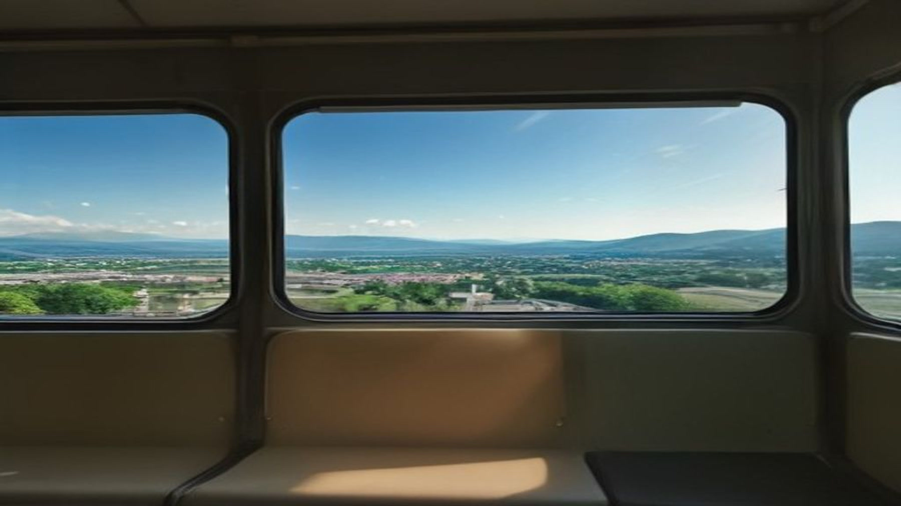 View from a regional Italian train window of dry hills and a pale town, travel as cost in travel romance books